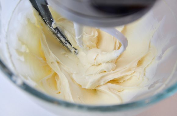 Cream cheese frosting in a clear mixing bowl
