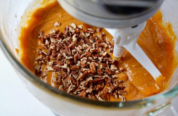 Pumpkin bars batter in mixing bowl with chopped pecans