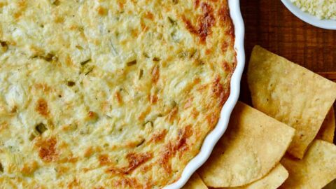 Top down view of Hot and Creamy Artichoke Dip next to tortilla chips