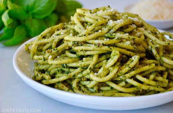 Basil pesto bucatini pasta on a white plate