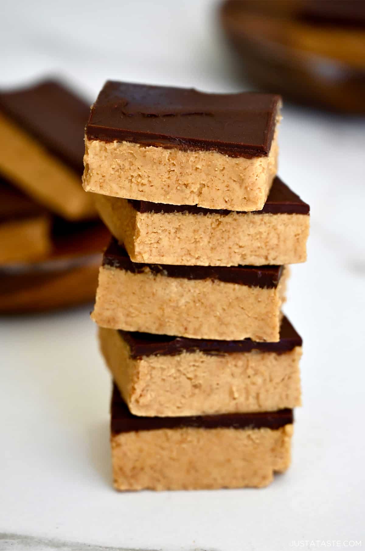 A tall stack of thick peanut butter bars with chocolate.