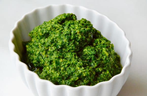 Puréed basil pesto pasta in a white dish
