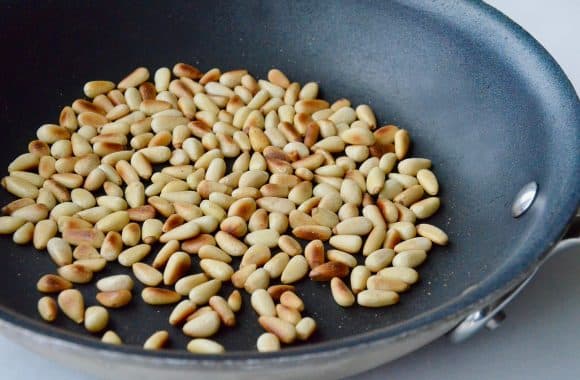 Toasted pine nute in a sauté pan