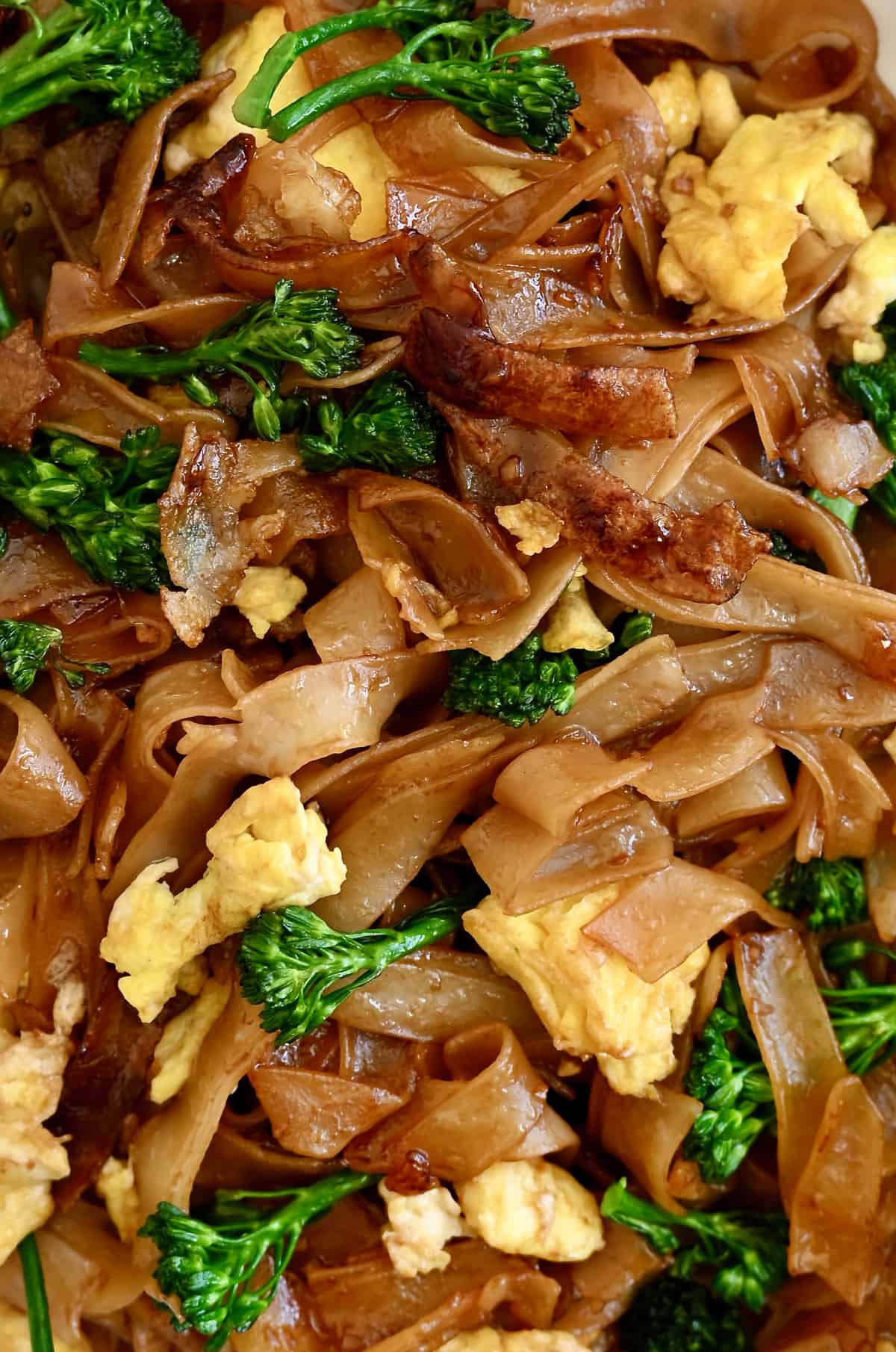 Thai stir-fried noodles with scrambled eggs and broccolini.