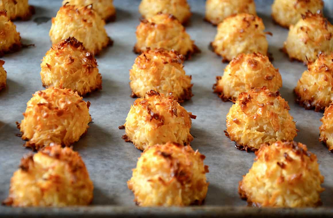 A baking sheet topped with wax paper and coconut macaroons