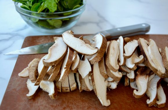 Sliced shiitakes on wood cutting board