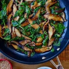 Skillet with sauteed mushrooms and spinach in a spicy garlic sauce