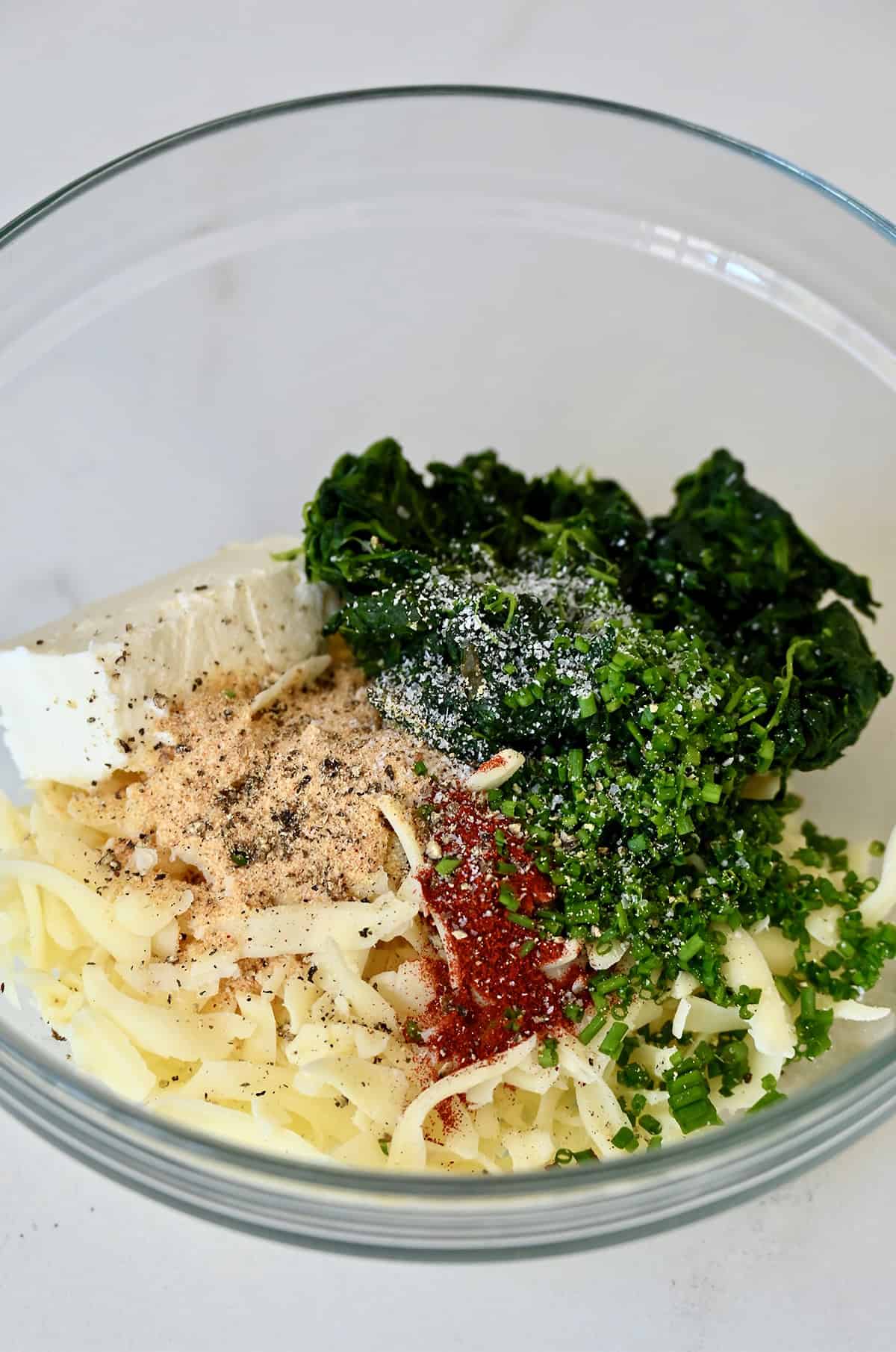 Spinach and mozzarella filling for stuffed chicken in a mixing bowl.