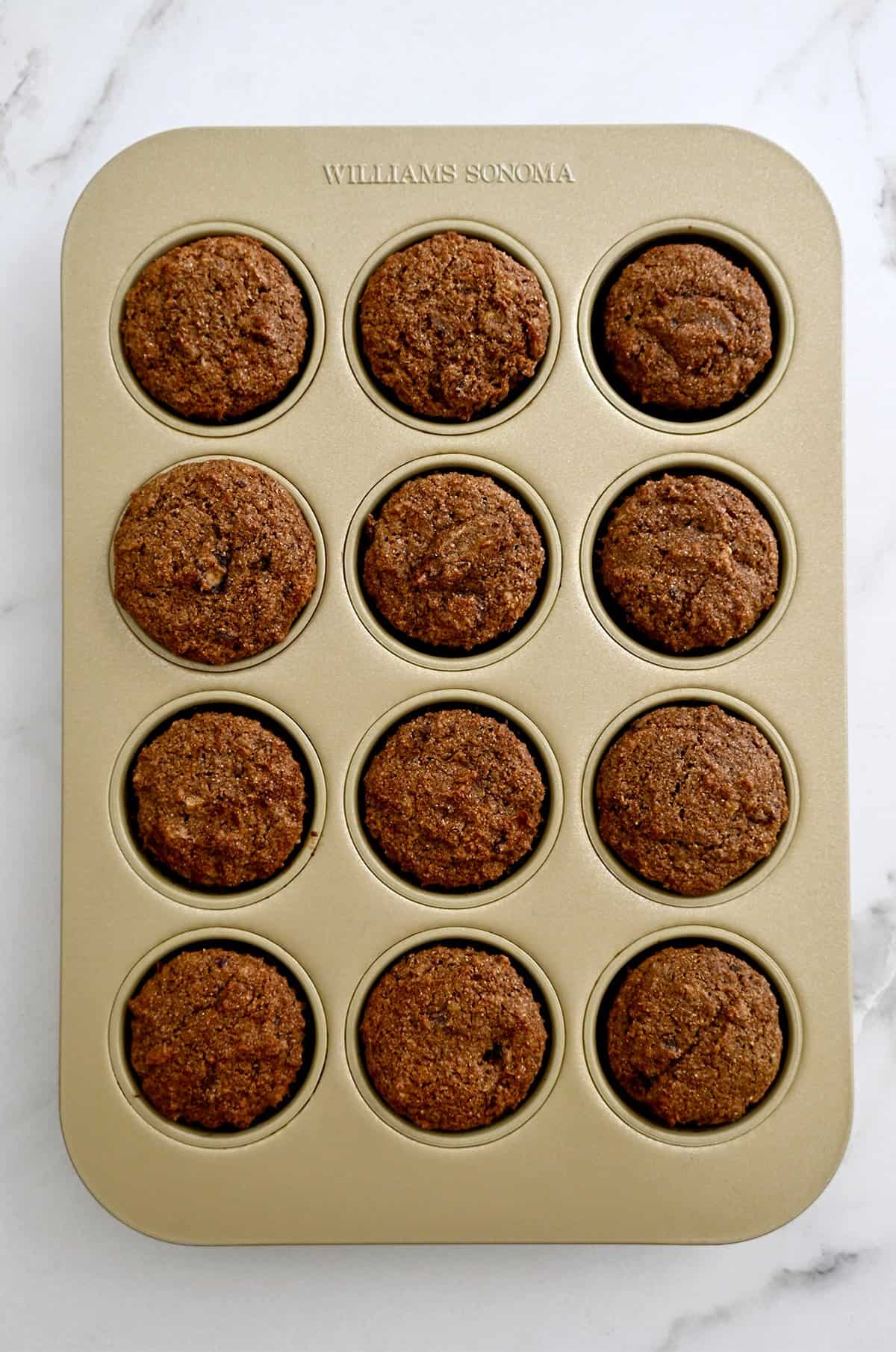 Freshly baked bran muffins in a 12-cup muffin tin.