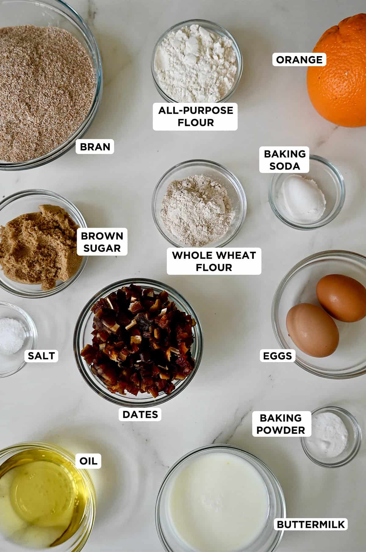 Various sizes of glass bowls containing ingredients to make bran muffins.