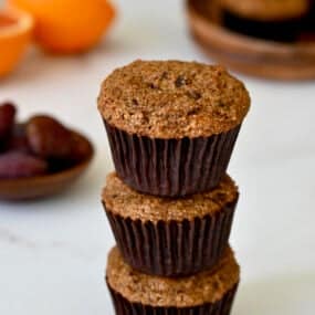Healthy bran muffins with orange zest stacked three high.