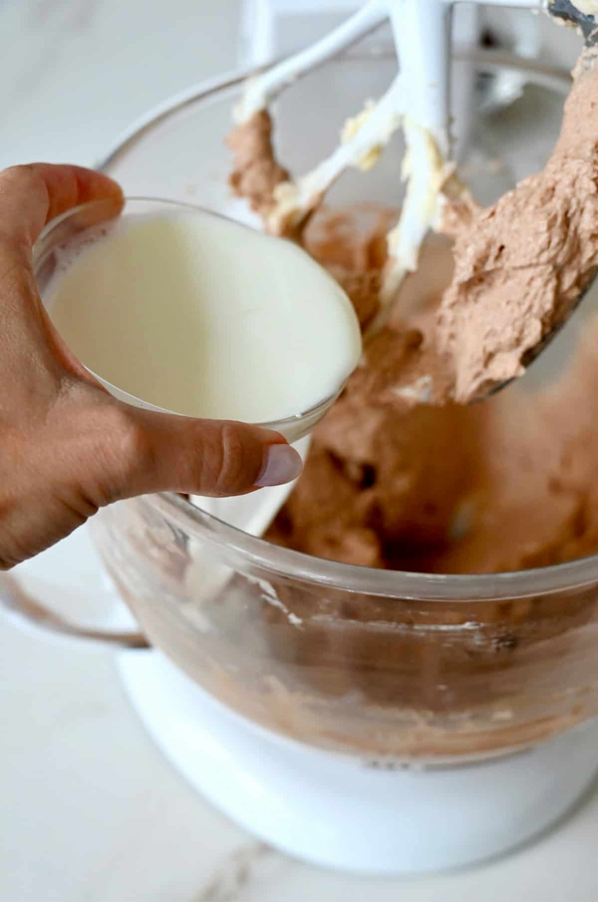 Adding whole milk to the chocolate loaf cake batter to thin it.