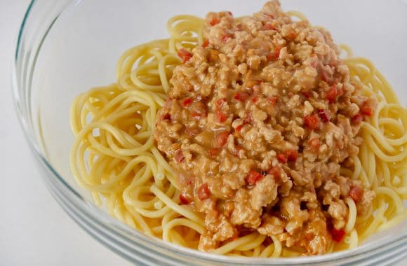 Clear bowl containing cooked pasta and turkey mixture 