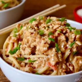 Dan Dan Noodles with Chicken in white bowl with chopsticks