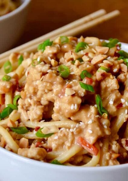 Dan Dan Noodles with Chicken in white bowl with chopsticks