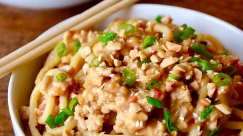 White bowl with chopsticks containing Dan Dan Noodles with Chicken
