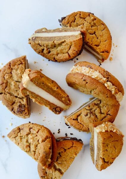 A top-down view of halved ice cream sandwiches on a white marble background