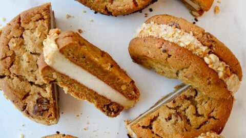 A top-down view of halved ice cream sandwiches on a white marble background