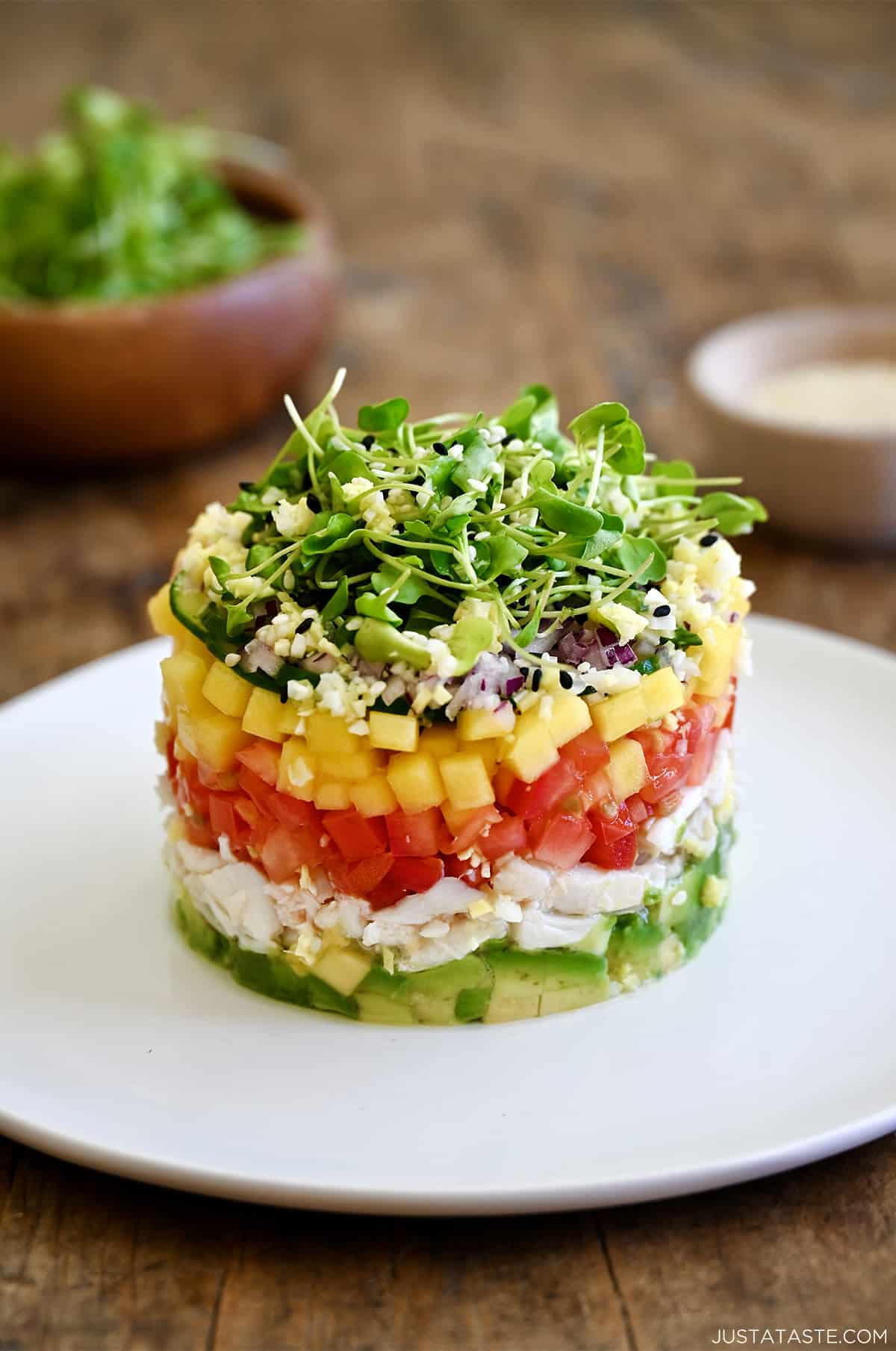 A crab stack with a layers of diced avocado, lump crab meat, diced tomato, diced mango, diced red onion and micro greens.