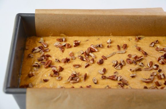 The Best Pumpkin Bread batter in a parchment paper-lined bread pan