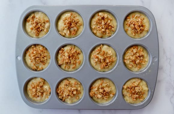 Unbaked banana batter topped with granola in muffin tin