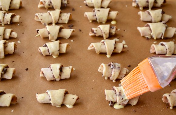 Applying egg wash to chocolate rugelach with brush