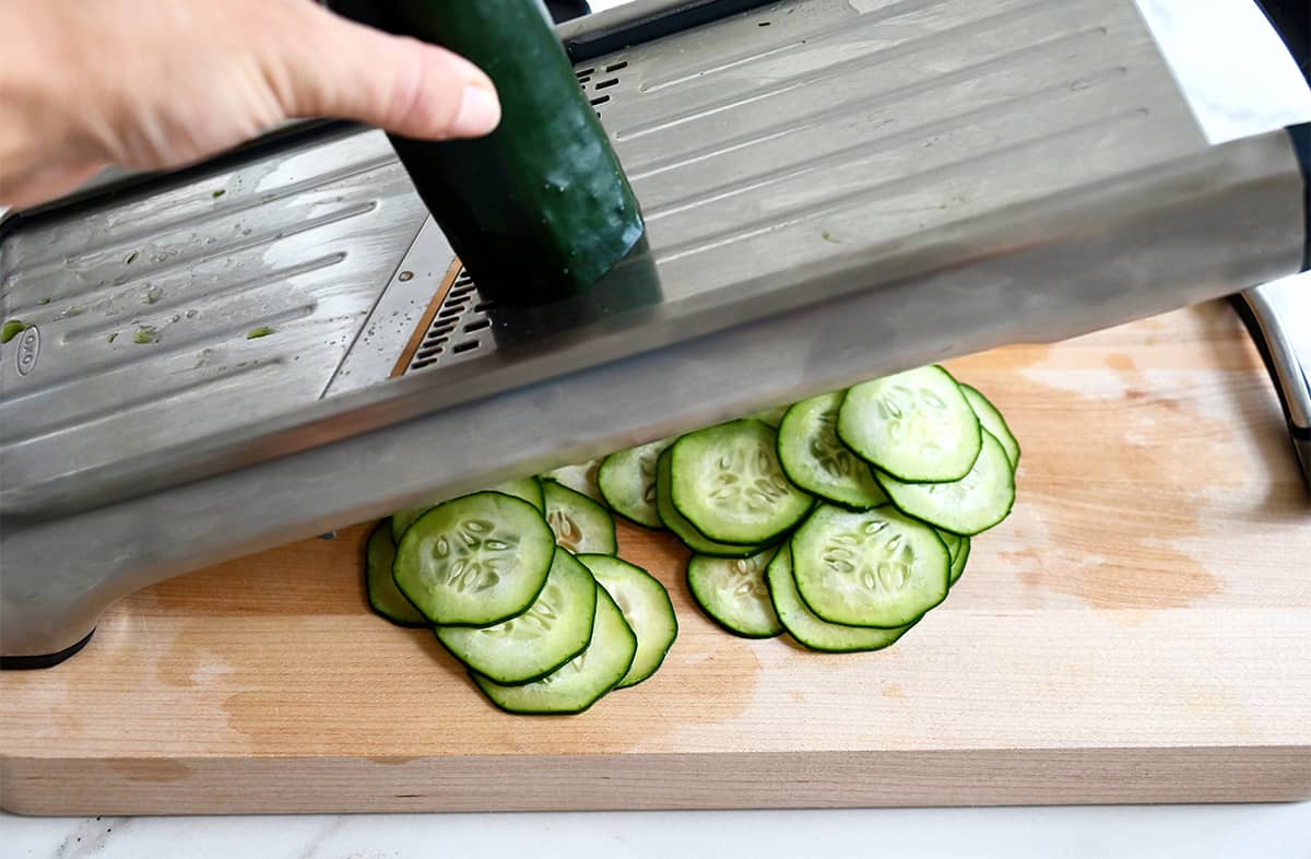 Slicing cucumbers on a mandolin.