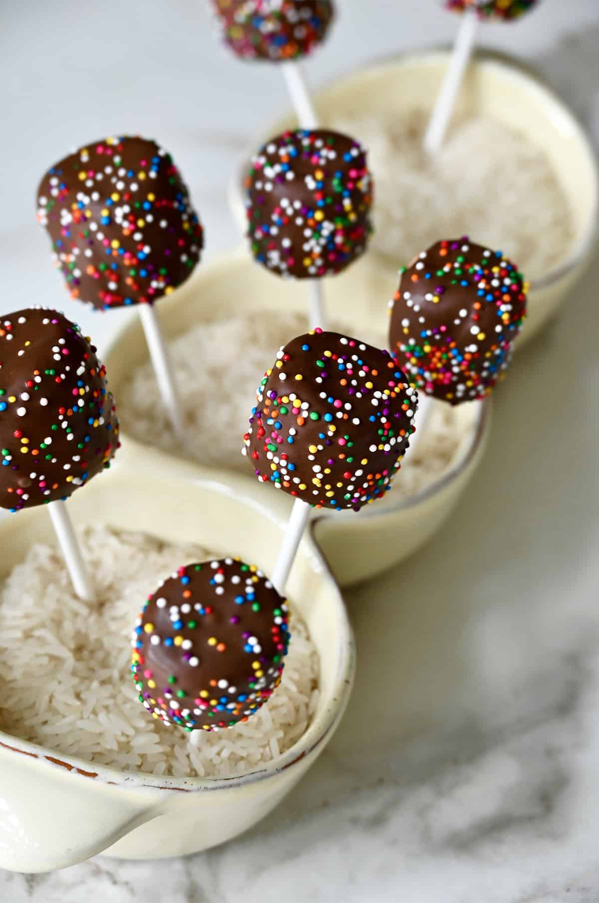Chocolate marshmallow pops with rainbow sprinkles.