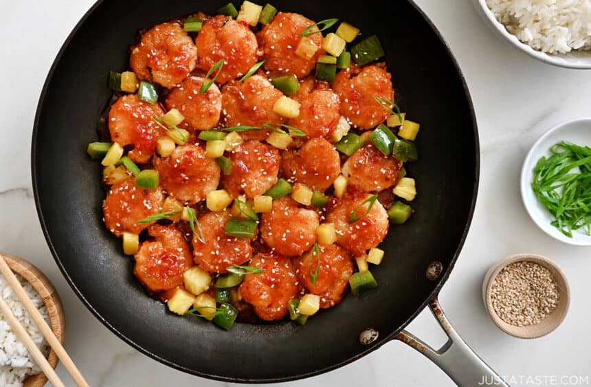 A nonstick skillet containing easy sweet and sour shrimp with pineapple and green pepper