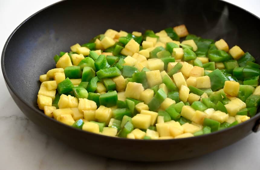 Sautéed chunks of pineapple and diced green pepper in a nonstick skillet
