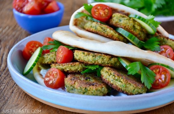 Easy Homemade Falafel tucked inside pita bread with Tahini Sauce, cucumbers, tomatoes and parsley