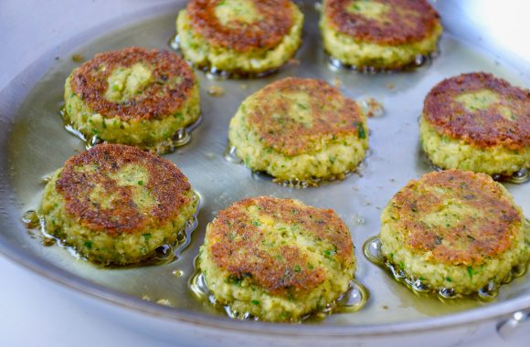 Browned falafel in sauté pan with oil. 