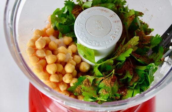 Chickpeas, parsley, cilantro, salt, chili powder and cumin in a bowl of a food processor