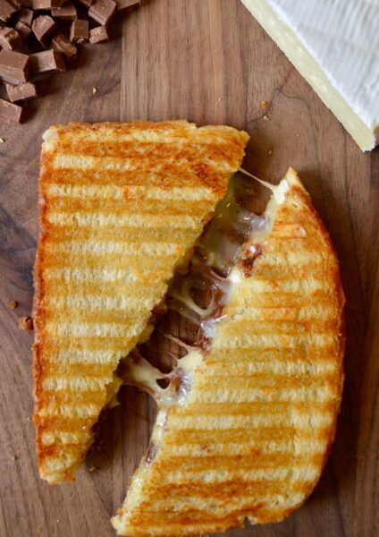 A Chocolate and Brie Panini sandwich on a wood cutting boar