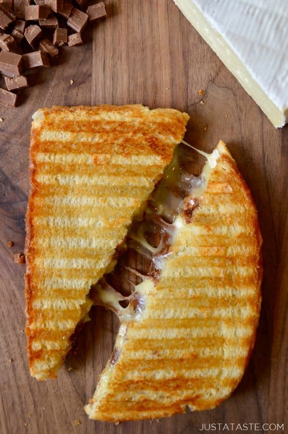 A Chocolate and Brie Panini sandwich on a wood cutting boar