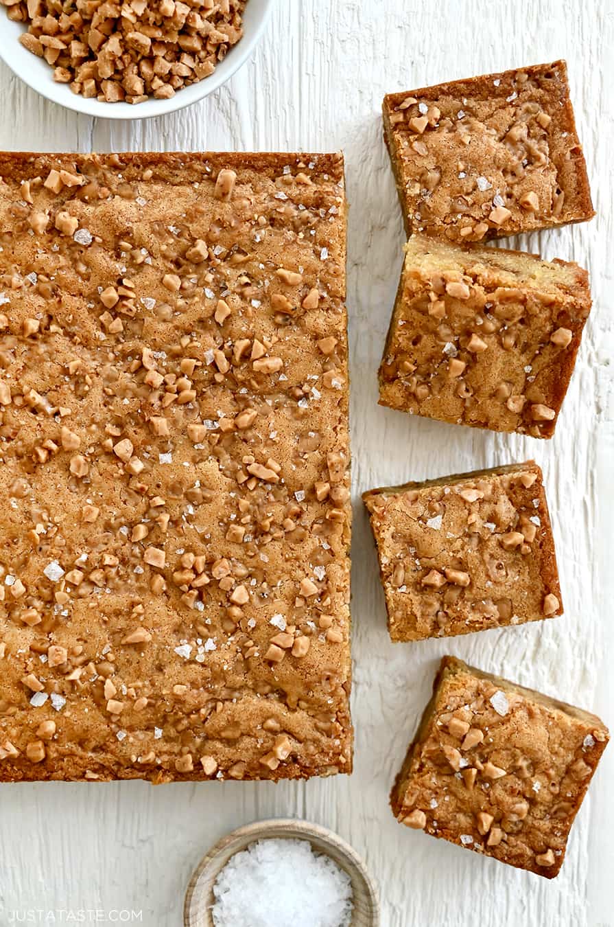 A top-down view of toffee blondies topped with toffee bits and large-flake sea salt.