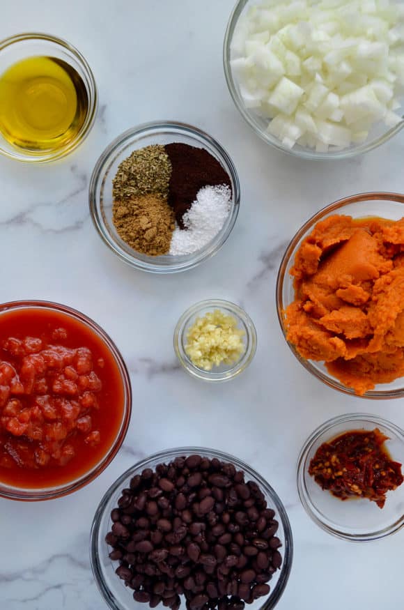 Glass bowls containing various ingredients for pumpkin chili