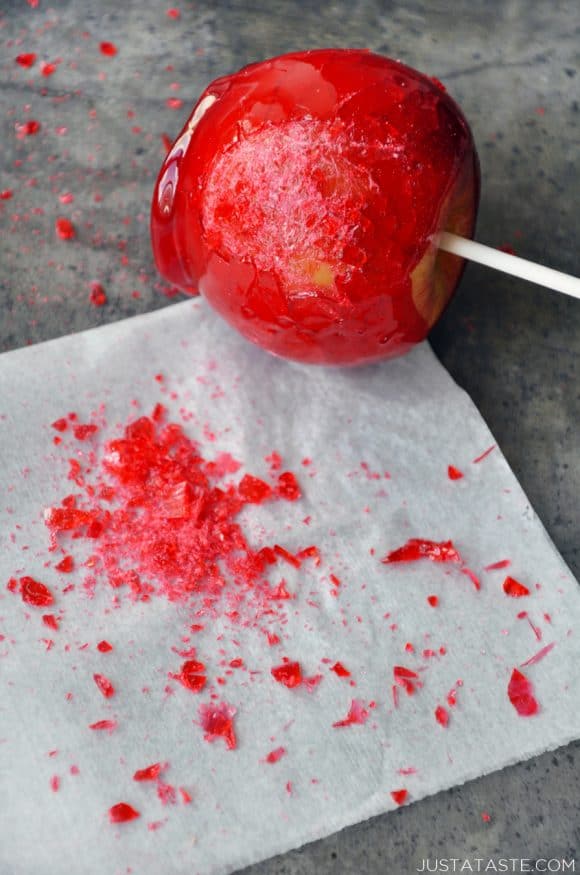 A candy apple that's been shattered on a piece of parchment paper