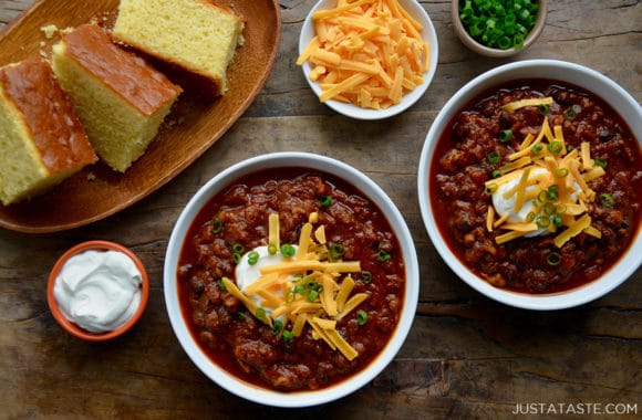 White bowls containing pumpkin chili with cheese and sour cream toppings