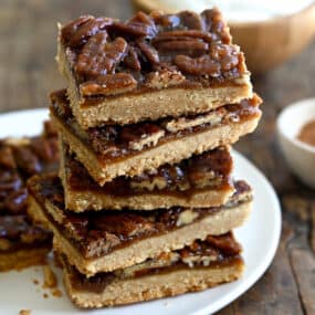 A stack of pecan pie bars on a white plate.
