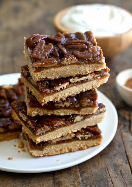 A stack of pecan pie bars on a white plate.
