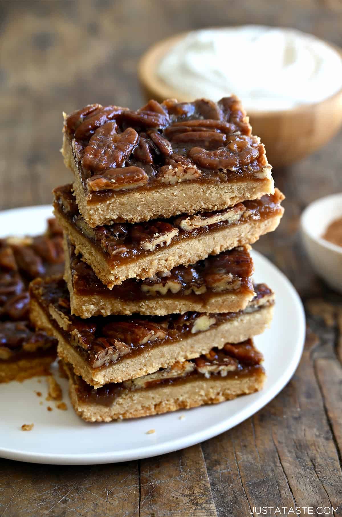 A stack of pecan pie bars on a white plate.