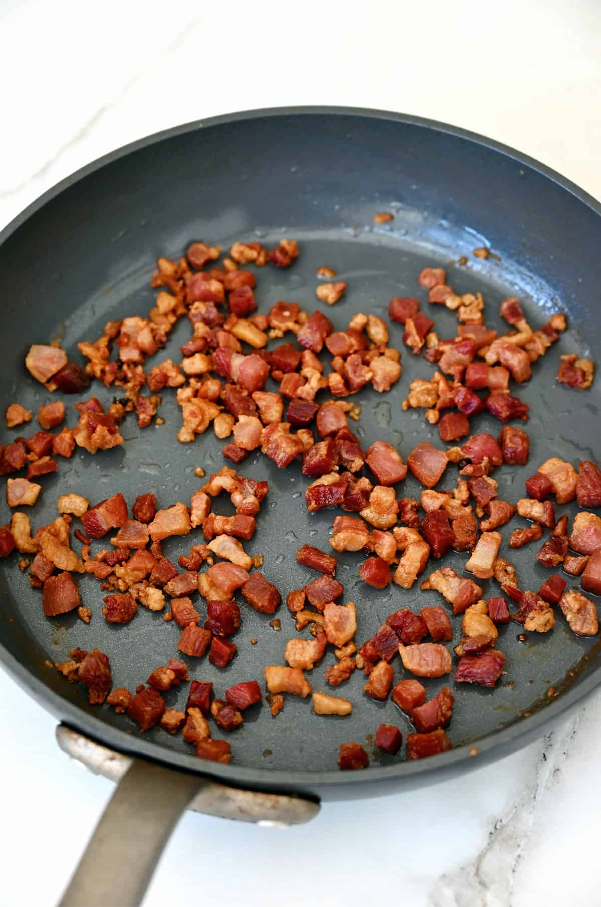 Crispy cooked pancetta pieces in a nonstick skillet.