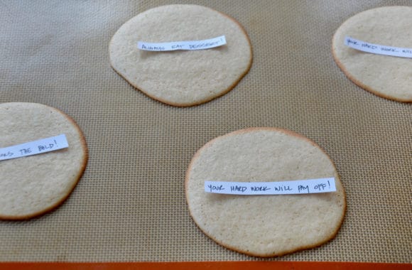 Handwritten fortunes on top of baked cookies