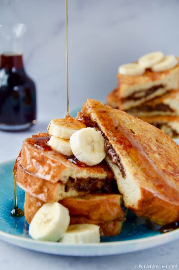 Banana and Nutella Stuffed French Toast topped with banana slices and drizzled with maple syrup