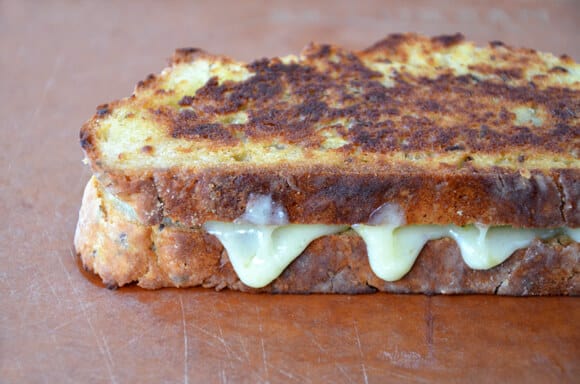 Irish Soda Bread Grilled Cheese with Pesto sits on a cutting board.