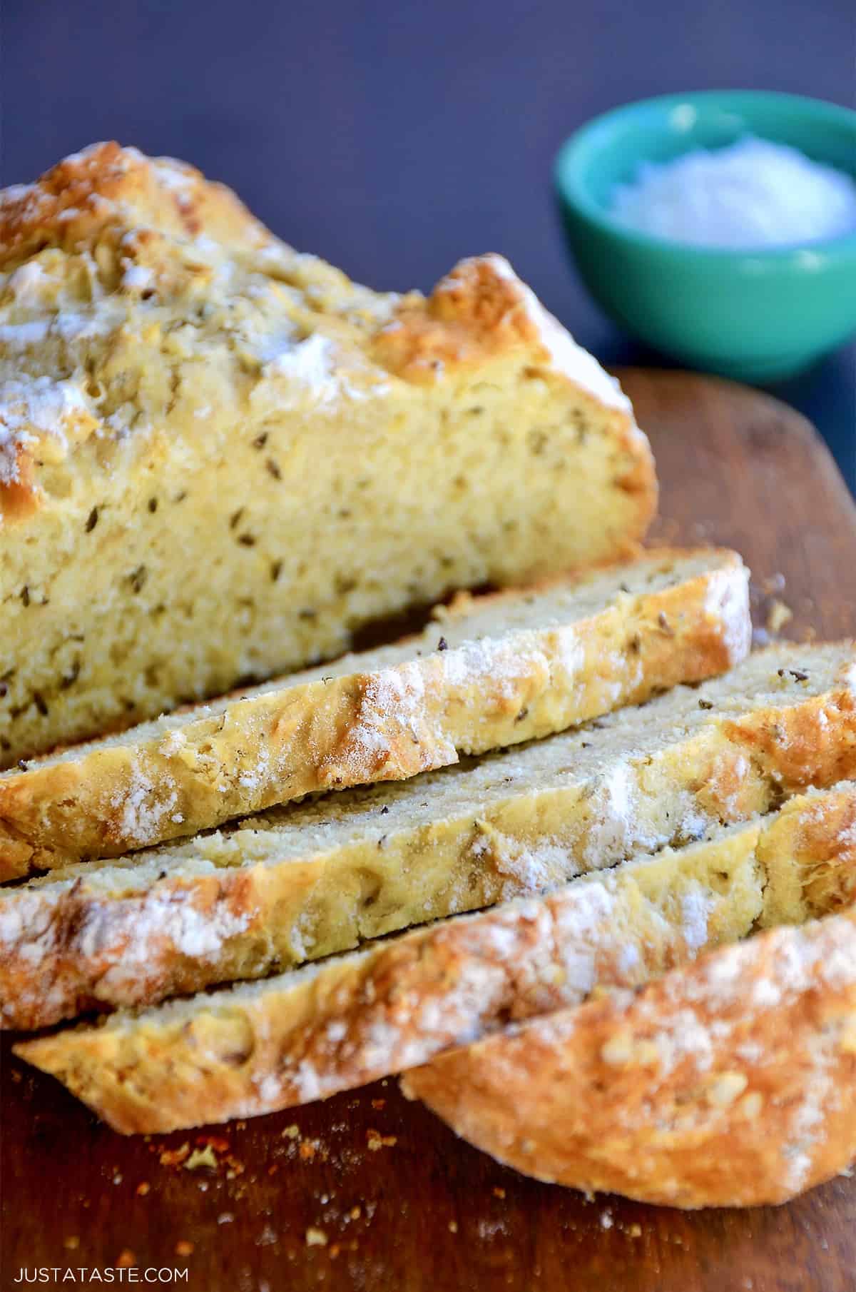 A loaf of homemade Irish soda bread sits on a flour-dusted surface.