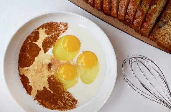 Banana Bread French Toast batter in white bowl with whisk