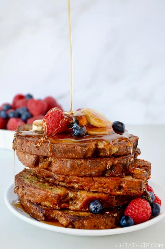 Stack of Banana Bread French Toast with maple syrup drizzle and fresh fruit