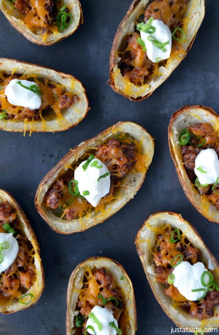 Baked potato skins with chorizo topped with dollops of sour cream and sliced scallions.